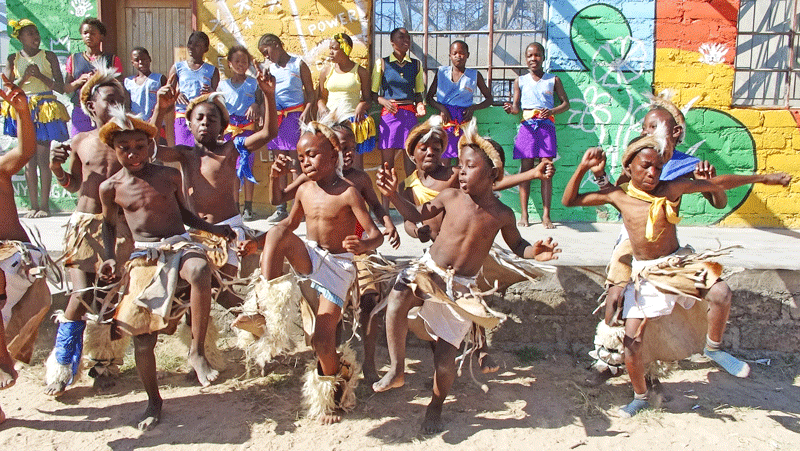 African boys in traditional dress performing a dance