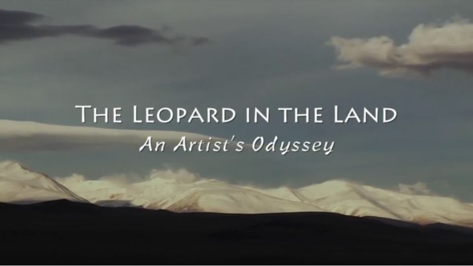 Words: "The Leopard in the Land An Artist's Odyssey across a landscape with mountains in the background